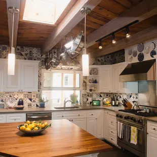 Solid walnut butcher-block island surface in center of refreshed, kitchen remodel. Lg window opens with countertop flowing through to patio.