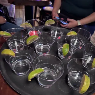 ows a tray of martinis with lime wedges