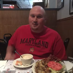 a man sitting at a table with a plate of food
