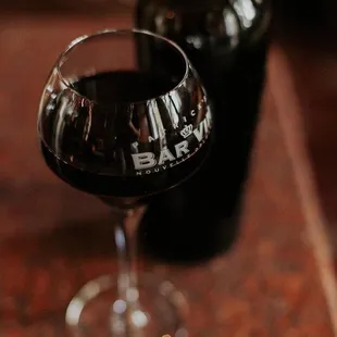 a glass of wine next to a bottle of wine