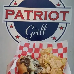 a hand holding a hot dog and chips