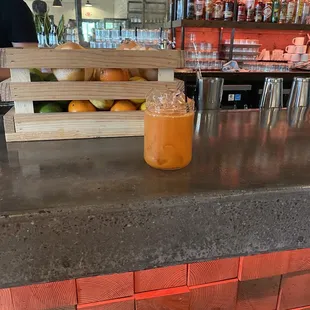 a glass of orange juice on a counter