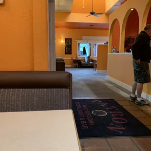 a man standing at a counter in a restaurant