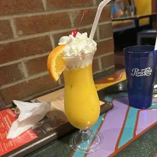 a drink with whipped cream and a slice of orange