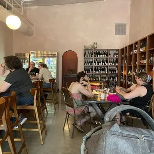 several people sitting at tables in a wine shop