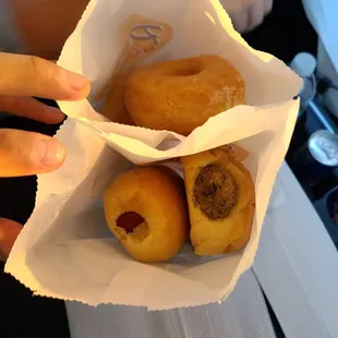 a person holding a bag of doughnuts