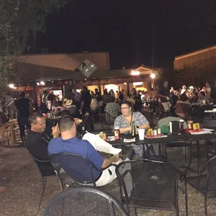 people sitting at tables outside at night
