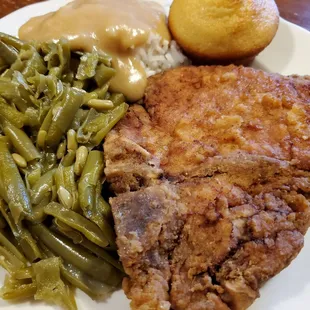 Pork chop plate, green beans, rice &amp; gravy, corn muffin (close-up)