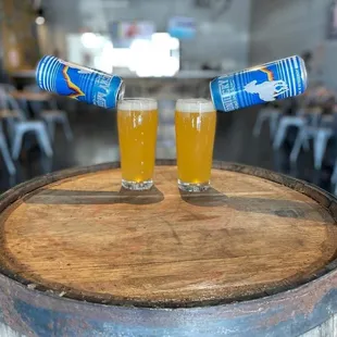 two glasses of beer on a barrel