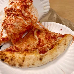 a slice of pizza on a paper plate