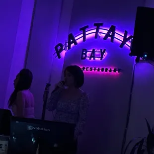 a woman standing in front of a neon sign