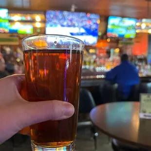 a hand holding a glass of beer