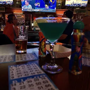 a drink and a lot of bingo cards