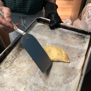 a person cutting a piece of bread