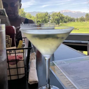 a woman sitting at a table with a glass of wine