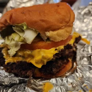 a hamburger with lettuce, tomato, and cheese