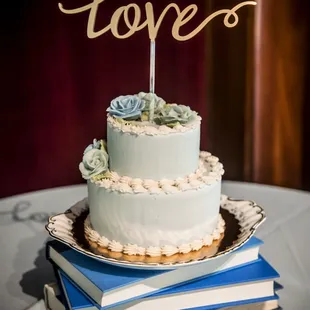 a wedding cake on a stack of books
