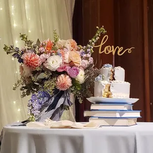 a table with a cake and flowers
