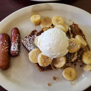 Banana Bread Foster: banana bread topped with sliced bananas, sautéed in butter, brown sugar, and cinnamon, topped with Devonshire cream.