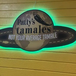 a neon sign for patty&apos;s tamales