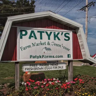 a sign for patyk's farm market and green people