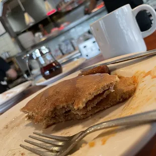 a half eaten pancake on a plate with a fork