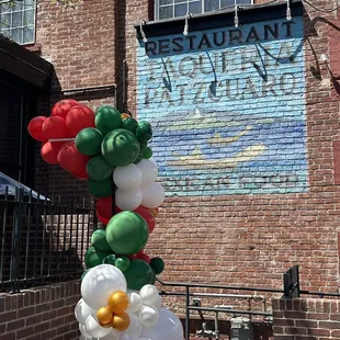 a colorful balloon arch in front of a restaurant