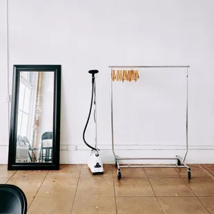 A thoughtfully arranged space at Pauahi Street Photo Studio, featuring a mirror, steamer, and clothing rack--perfect for fashion and styling