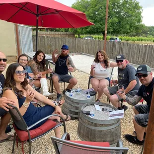a group of people sitting around a wine barrel