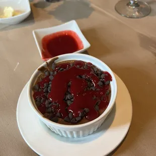 Chocolate mousse, chocolate chips, and raspberry sauce .