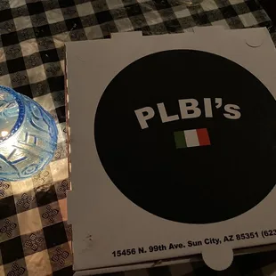 a pizza box and a glass of water