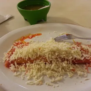 Enchilada Mexicana. Tortilla cooked in a red sauce with queso fresco inside and crumbled on to as well.