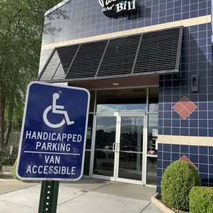 a handicap parking sign in front of a building