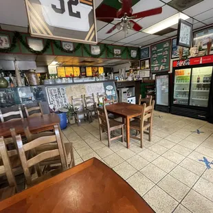 Dining area, including a half-full beverage refrigerator and stuff stored in the corner.