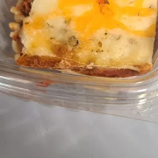 a slice of lasagna in a plastic container