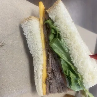 a roast beef sandwich with cheese and lettuce