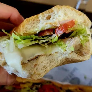 a hand holding a sandwich