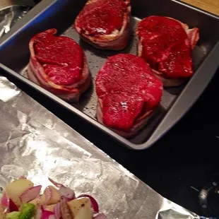 a pan of steaks and vegetables