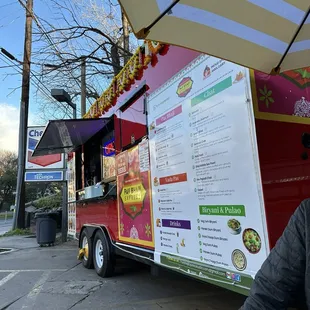 a man sitting in front of a food truck