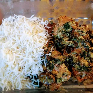 a plate of rice, meat and vegetables