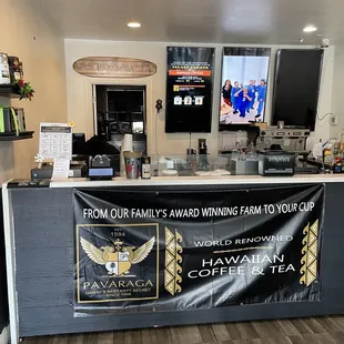 a coffee shop counter with a banner on it