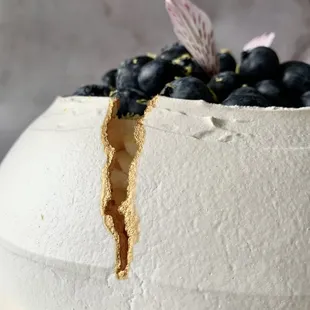 a white cake with blueberries on top