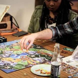 A couple tries their luck at "Smallworld"