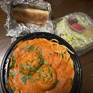 a plate of spaghetti and a hot dog