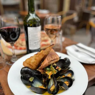 a plate of mussels and a glass of wine