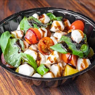 a bowl of salad on a wooden table