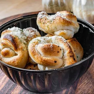 a bowl of bread rolls on a table