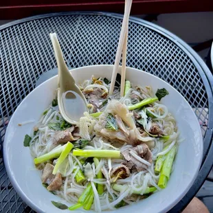 a bowl of noodles with meat and vegetables