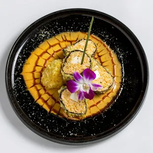 a black plate with a purple flower