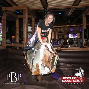  a woman riding a cow